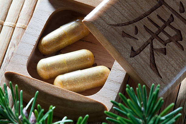 Pills in wooden box with Chinese word on top. Concept for herbal medicine